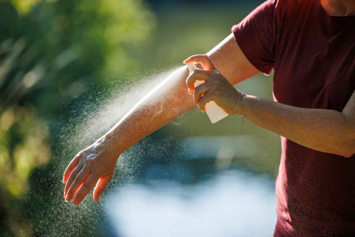 Person applies bug spray to avoid mosquito bites